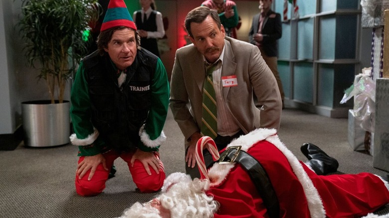 Will Arnett as Detective Seattle and Jason Bateman as himself, kneeling over Santa's body in Who Killed Santa? A Murderville Mystery