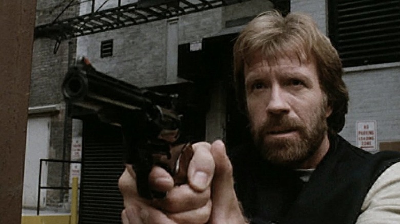 Chuck Norris as Cusack pointing gun in Code of Silence