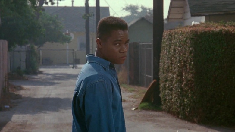 Cuba Gooding Jr. as Jason "Tre" Styles, III in Boyz in the Hood, standing in an alley and looking forebodingly into the distance past the camera.