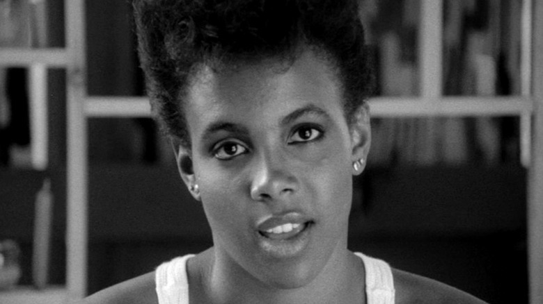 Tracy Camilla Johns as Nola Darling in She's Gotta Have It, in black-and-white and looking right past the camera as the speaks.