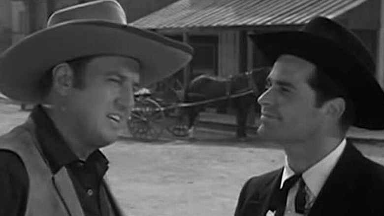 Bret Maverick (James Garner) grins while looking at Mort Dooley (Ben Gage) in Maverick