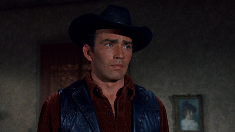 The Virginian (James Drury) stands looking thoughtfully in The Virginian