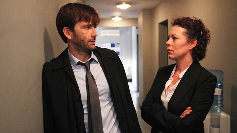 Alec Hardy (David Tennant) speaks with Ellie Miller (Olivia Colman) in a narrow hallway in Broadchurch