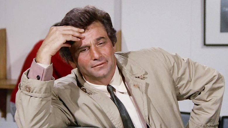 A disheveled Frank Columbo (Peter Falk) puts his hand on his head in Columbo