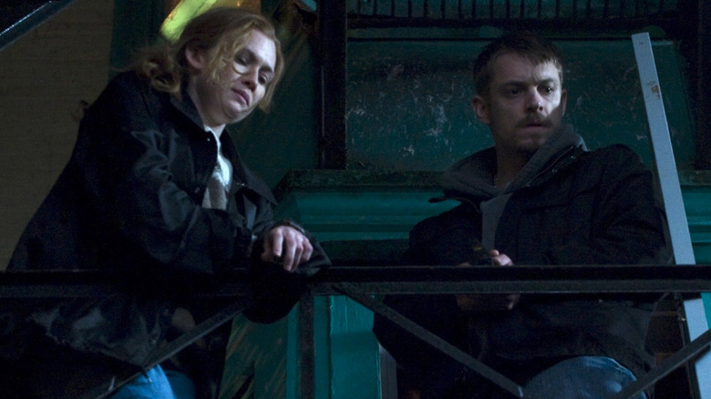 Stephen Holder (Joel Kinnaman) and Sarah Linden (Mireille Enos) standing on a fire escape in The Killing