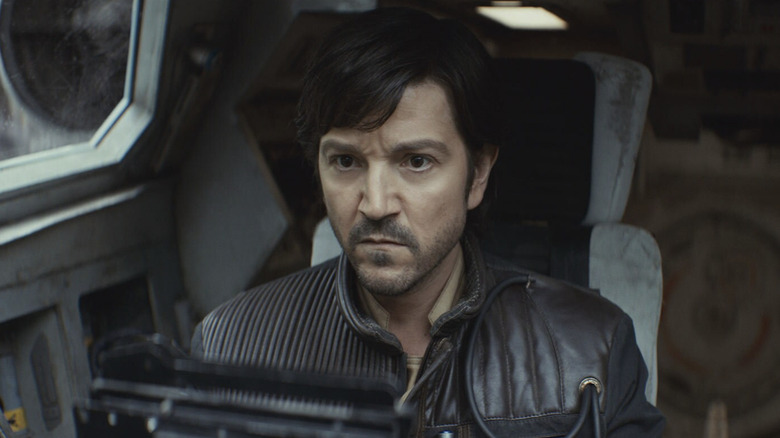 Diego Luna as Cassian Andor looking serious and wearing a jacket in the cockpit of a ship in Andor