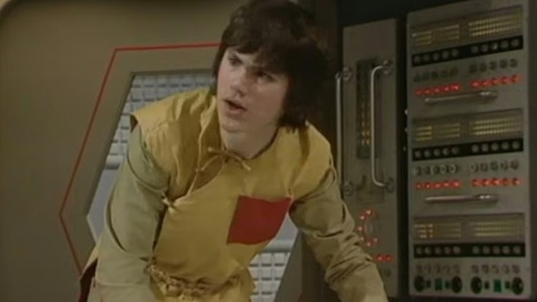 Adric (Matthew Waterhouse) looks up from a futuristic console in Doctor Who