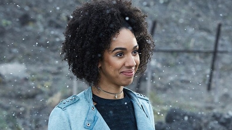 Bill Potts (Pearl Mackie) stands smiling in the snow in Doctor Who