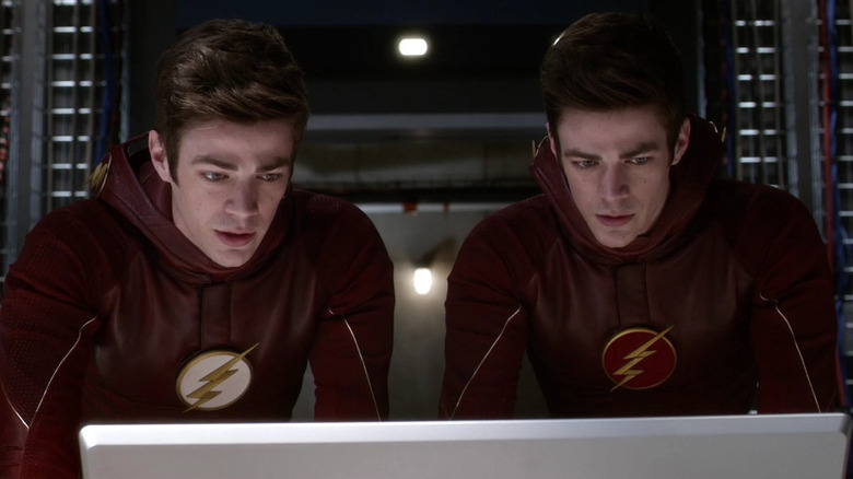 Grant Gustin as two different versions of Barry Allen, looking over a computer on The Flash