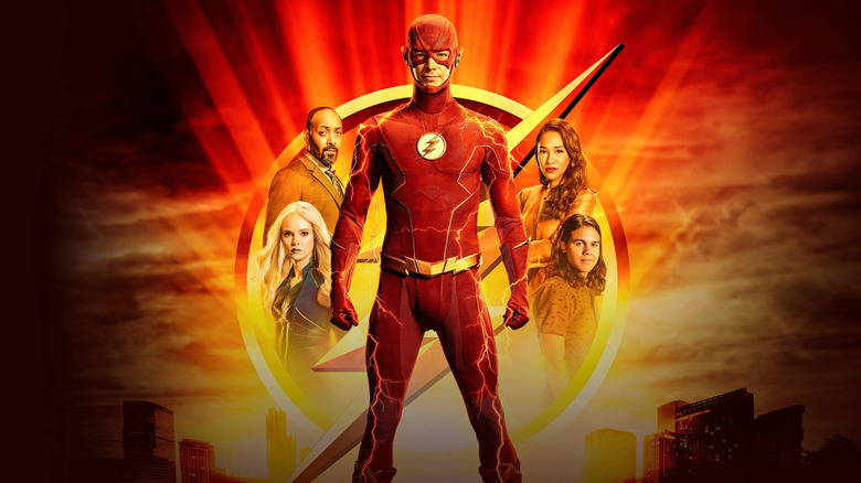 The cast of The Flash standing within the Flash symbol