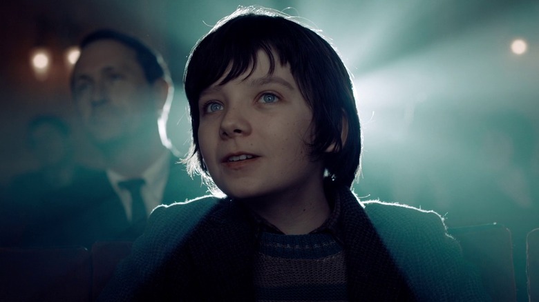 Asa Butterfield as Hugo Cabret in Hugo, lit from behind by the glow of a film projector.