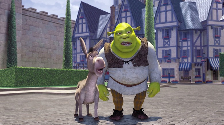 Mike Meyers as Shrek and Eddie Murphy as Donkey in Shrek, standing next to each other in a town, looking at something with surprise.