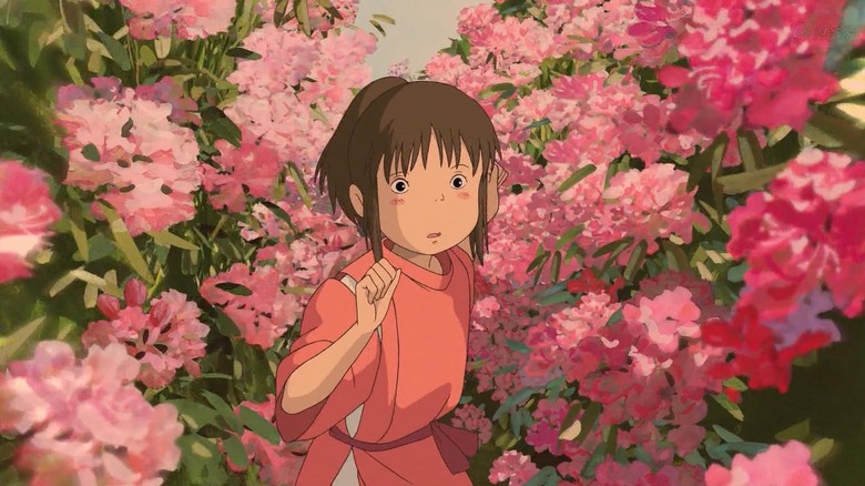 Rumi Hiiragi (or Daveigh Chase in the English version) as Chihiro Ogino / Sen in Spirited Away, making her way with trepidation through bushels of pink flowers.