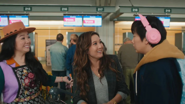 Lolo Chen (Sherry Cola) and Audrey Sullivan (Ashley Park) smile at Deadeye (Sabrina Wu) in Joy Ride (2023)