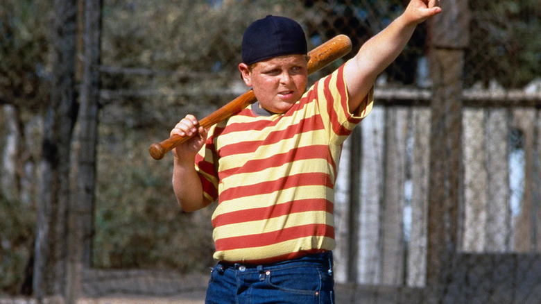 Ham Porter (Patrick Renna) points to the outfield while holding a baseball bat in The Sandlot