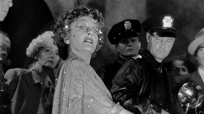Norma Desmond (Gloria Swanson) is escorted by the police in Sunset Boulevard
