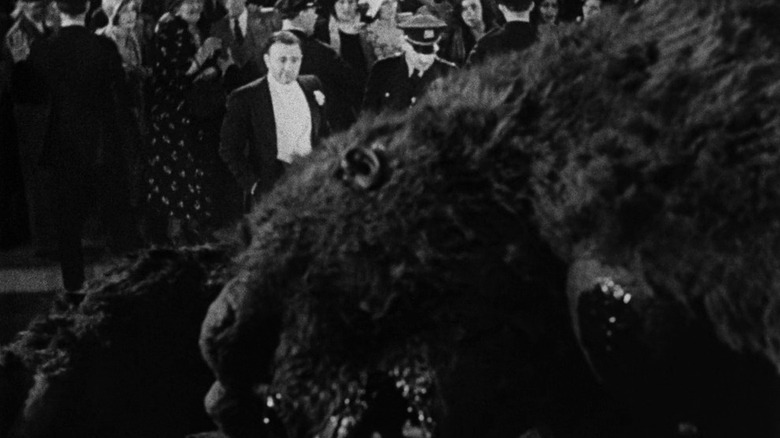 Carl Denham (Robert Armstrong) looks over a dead King Kong in King Kong (1933)
