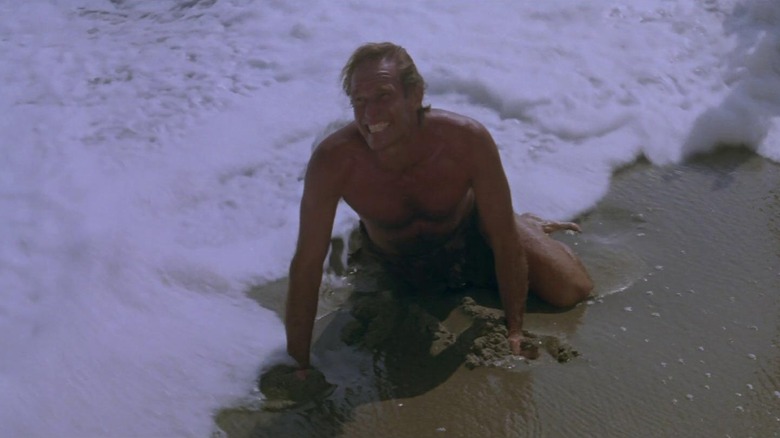 George Taylor (Charlton Heston) screams while kneeling on a beach in Planet of the Apes (1968)