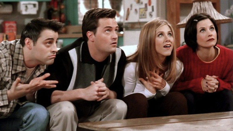 Matt LeBlanc as Joey Tribbiani, Matthew Perry as Chandler Bing, Jennifer Aniston as Rachel Green, and Courteney Cox as Monica Geller playing trivia in the Friends episode "The One With the Embryos"