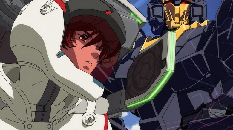 Banagher Links stands before a Gundam in Mobile Suit Gundam Unicorn