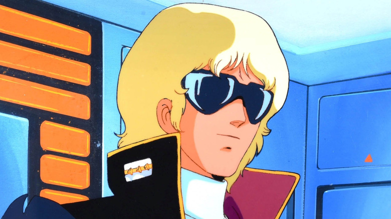 Quattro Bajeena stands with sunglasses on and his collar up in Mobile Suit Zeta Gundam