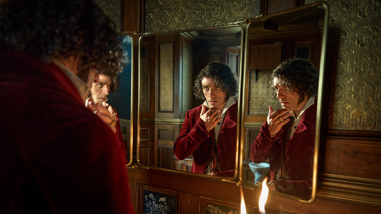 Oscar Isaac as Victor eyes his reflection in a three-part mirror in Frankenstein (2025)