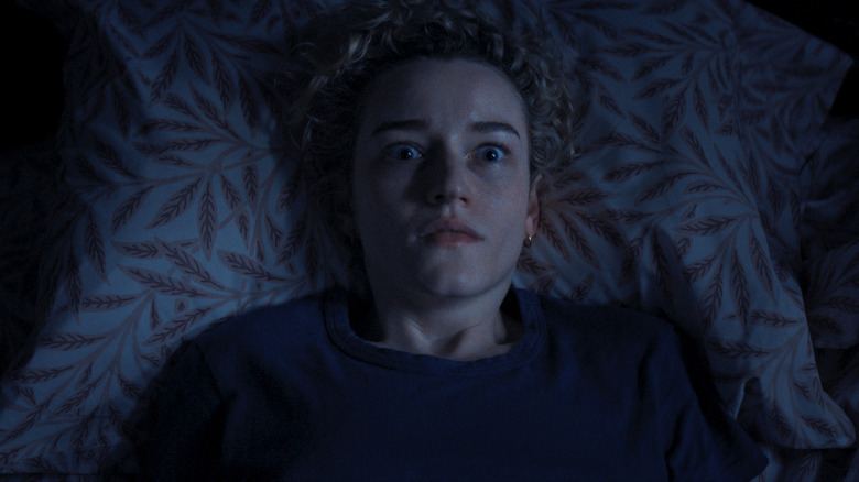 Julia Garner's Justine Gandy lying in the bed with her eyes wide open in Weapons