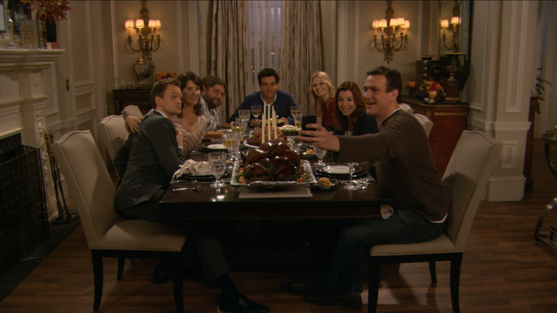 The gang, along with The Blitz (Jorge Garcia) and Zoe (Jennifer Morrison), take a group selfie during dinner in How I Met Your Mother