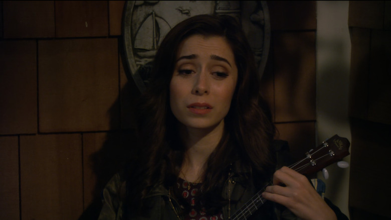Tracy McConnell (Cristin Millioti) sings while playing her ukelele against a wall in How I Met Your Mother