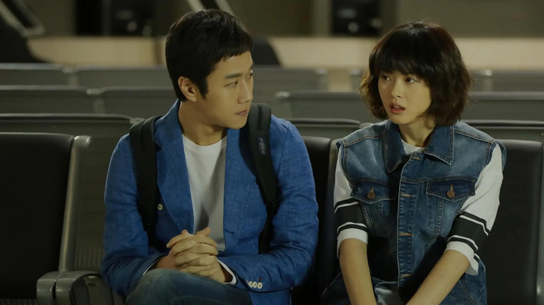 Sseureki (Jung Woo) sits next to Sung Na-jung (Go Ara) in a classroom in Reply 1994