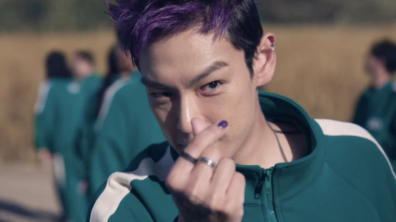 Thanos (T.O.P.) flashes a heart sign in Squid Game