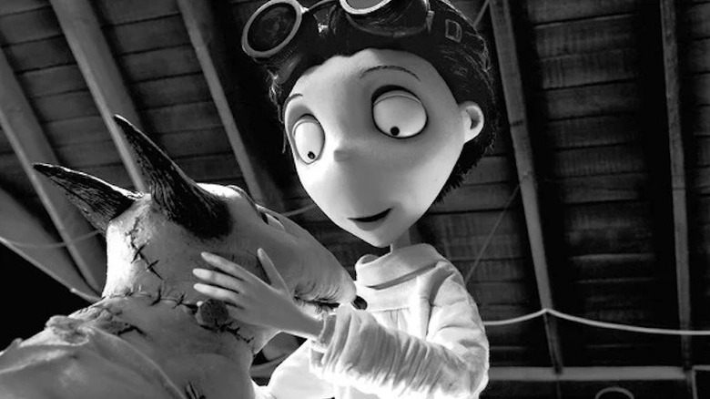 Animated boy with goggles on head holding the face of dog with stitches in it in Frankenweenie