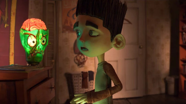 Animated kid with spiky black hair looking at angry green zombie face in ParaNorman