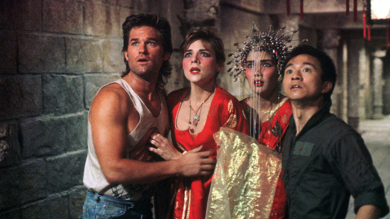 Kurt Russell as Jack Burton looks worried with Gracie Law (Kim Cattrall), Miao Yin (Suzee Pai), and Wang Chi (Dennis Dun) in Big Trouble in Little China