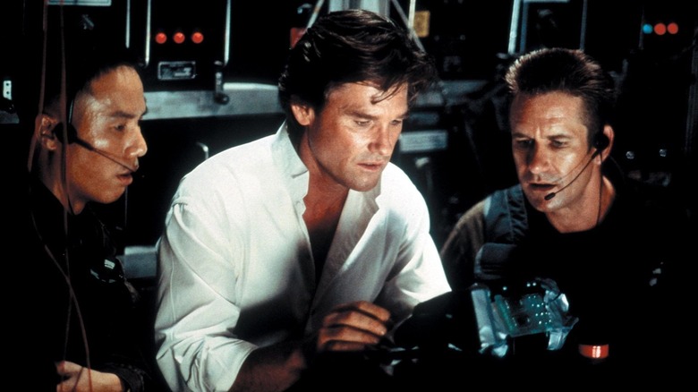 BD Wong as Staff Sergeant Louie Jung, Kurt Russell as Dr. David Grant, and Whip Hubley as Sergeant 1st Class Michael Baker look at a device in Executive Decision