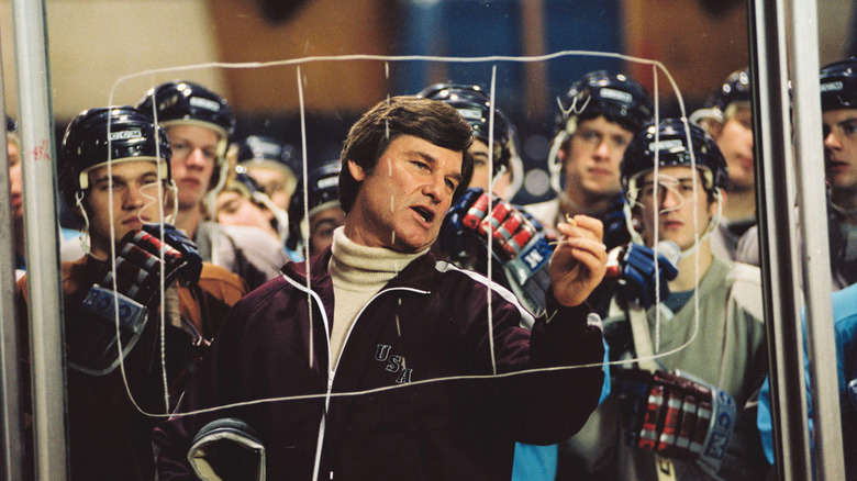 Kurt Russell as Herb Brooks drawing a play on the hockey rink glass in Miracle
