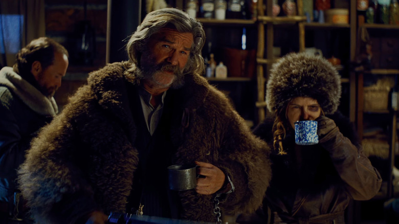 Kurt Russell as John "The Hangman" Ruth sips coffee next to Jennifer Jason Leigh as "Crazy" Daisy Domergue in The Hateful Eight