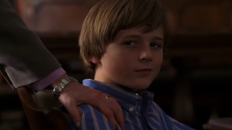 Jake O'Hara (Jordan Garrett) smiles smugly with a hand on his shoulder in Law & Order: Special Victims Unit
