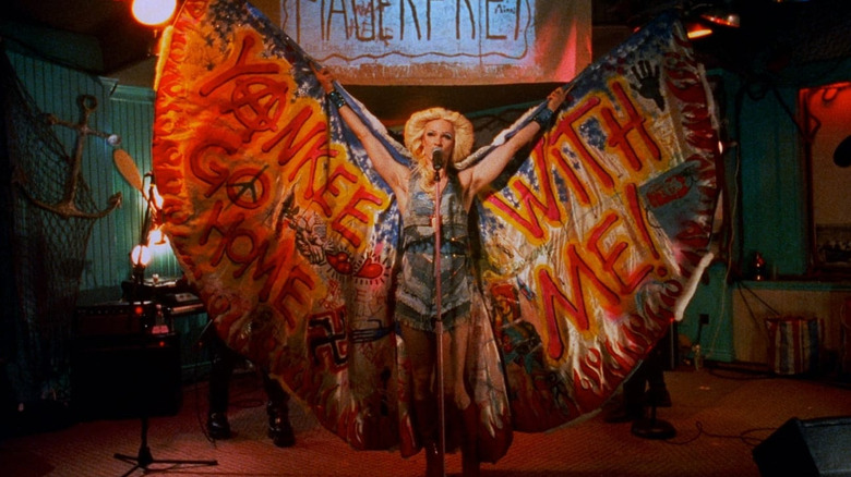 John Cameron Mitchell as Hedwig with a decorated wingspan cape on stage in Hedwig and the Angry Inch