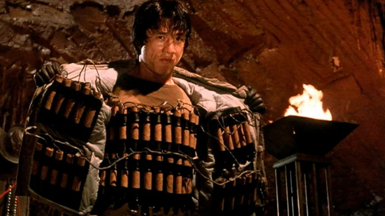 Asian Hawk (Jackie Chan) stands with a jacket full of explosives in Armour of God