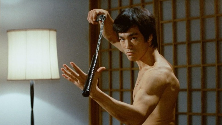 Chen Zhen (Bruce Lee) holds a nunchaku in Fist of Fury