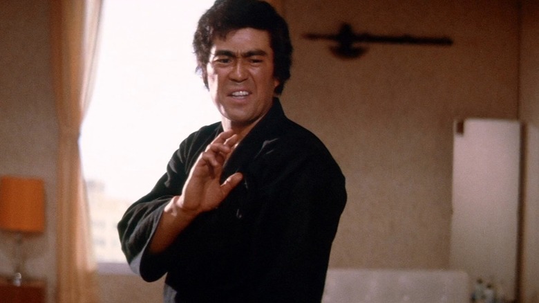 Takuma Tsurugi (Sonny Chiba) strikes a fighting pose in his apartment in The Street Fighter (1974)