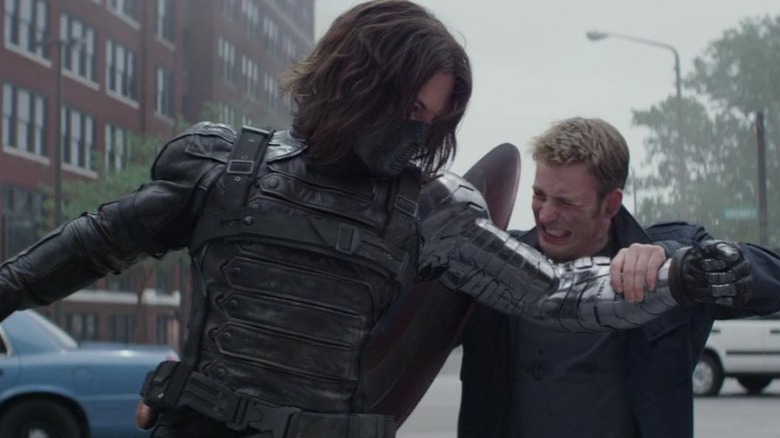 Chris Evans as Steve Rogers and Sebastian Stan as Bucky Barnes in Captain America: The Winter Soldier, engaged in a fight as Rogers grabs Bucky's arm.