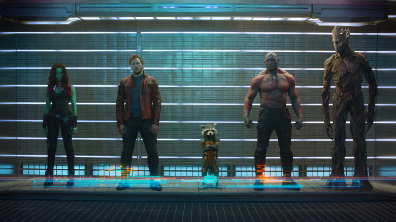 Chris Pratt as Peter Quill / Star-Lord, Zoe Saldaña as Gamora, Dave Bautista as Drax the Destroyer, Vin Diesel as Groot, and Bradley Cooper as Rocket, standing in a lineup.