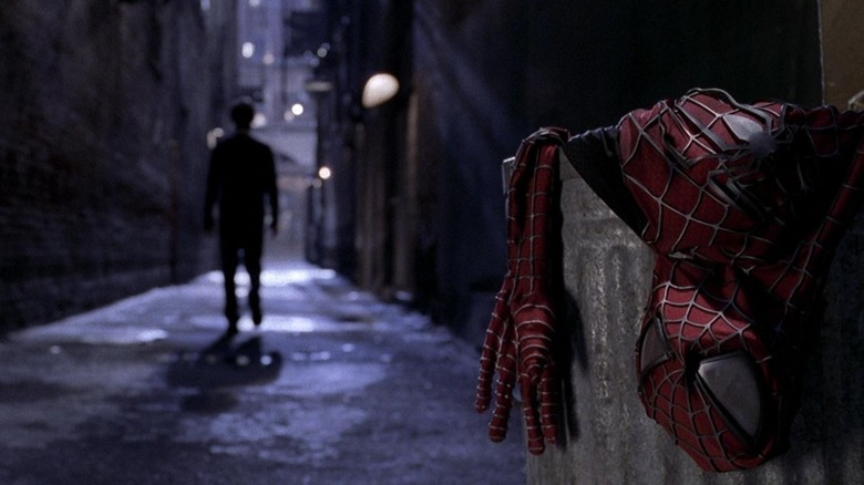 Tobey Maguire as Peter Parker/Spider-Man in Spider-Man 2, walking away from his discarded suit in a dark alleyway.