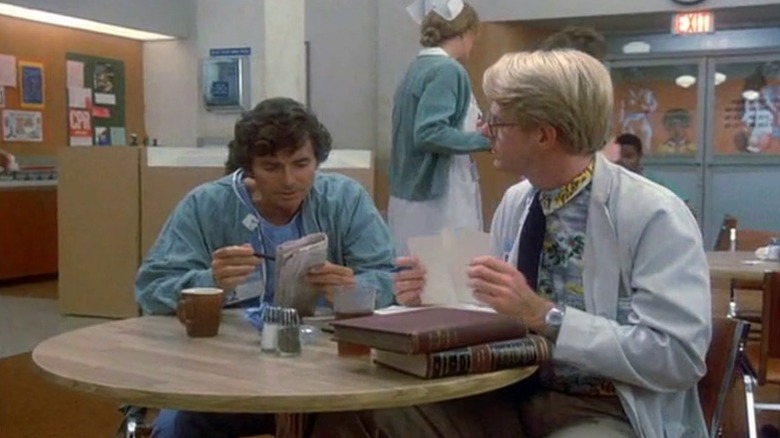 David Birney as Dr. Ben Samuels and Ed Begley Jr. as Dr. Victor Ehrlich sitting at a table on St. Elsewhere