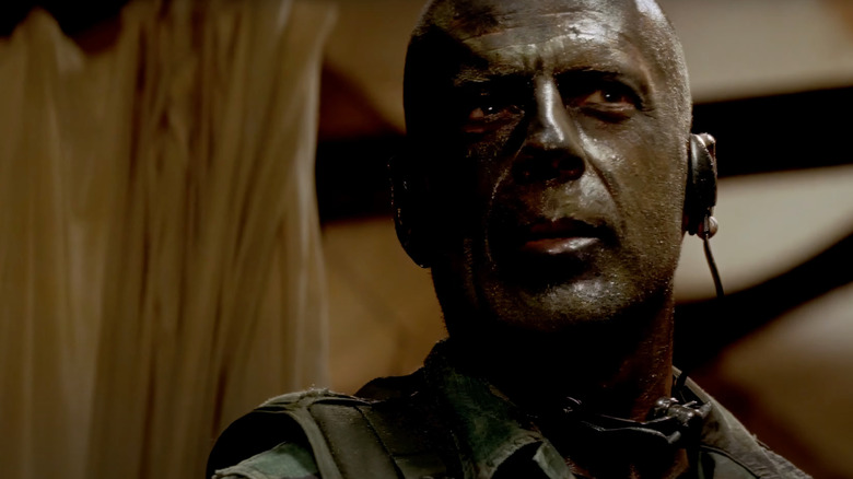 Bruce Willis as Lieutenant Alec Kevin 'A.K.' Waters covered in mud in Tears of the Sun