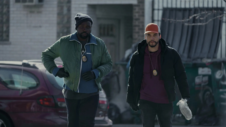 Ray Driscoll (Brian Tyree Henry) and Manny Carvalho (Wagner Moura) walk down a street together wearing badges in Dope Thief