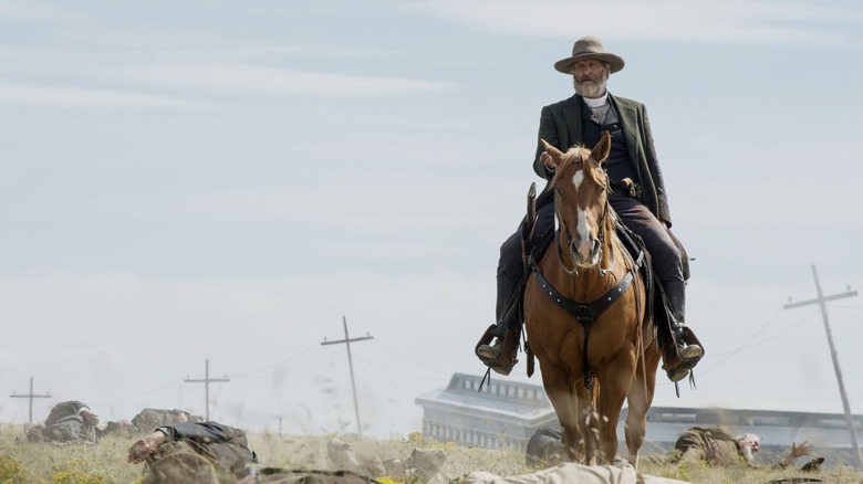 Frank Griffin (Jeff Daniels) rides a horse through a field of bodies in Godless