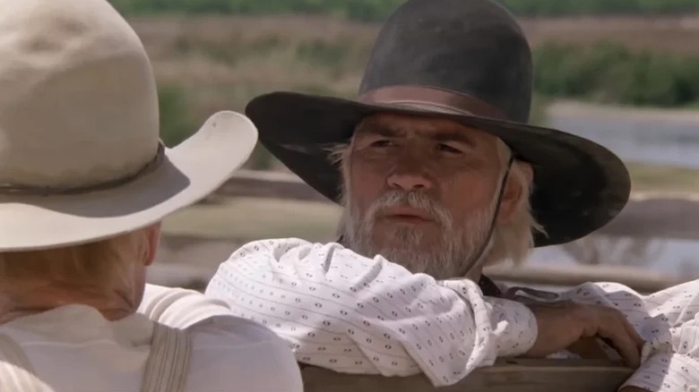 Woodrow Call (Tommy Lee Jones) looks at Gus McCrae (Robert Duvall) while leaning on a fence in Lonesome Dove